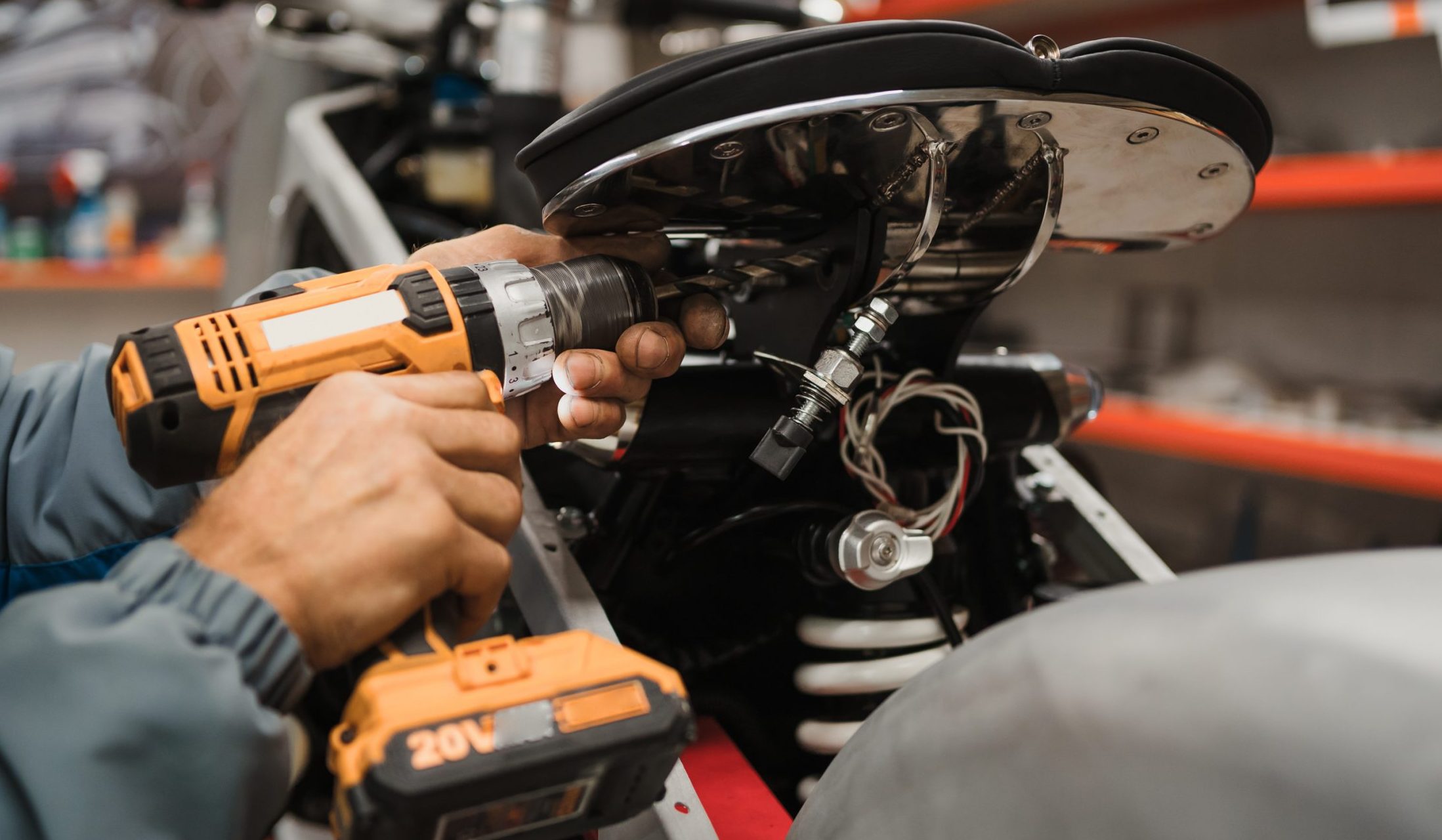 man fixing a motorcycle in a modern workshop