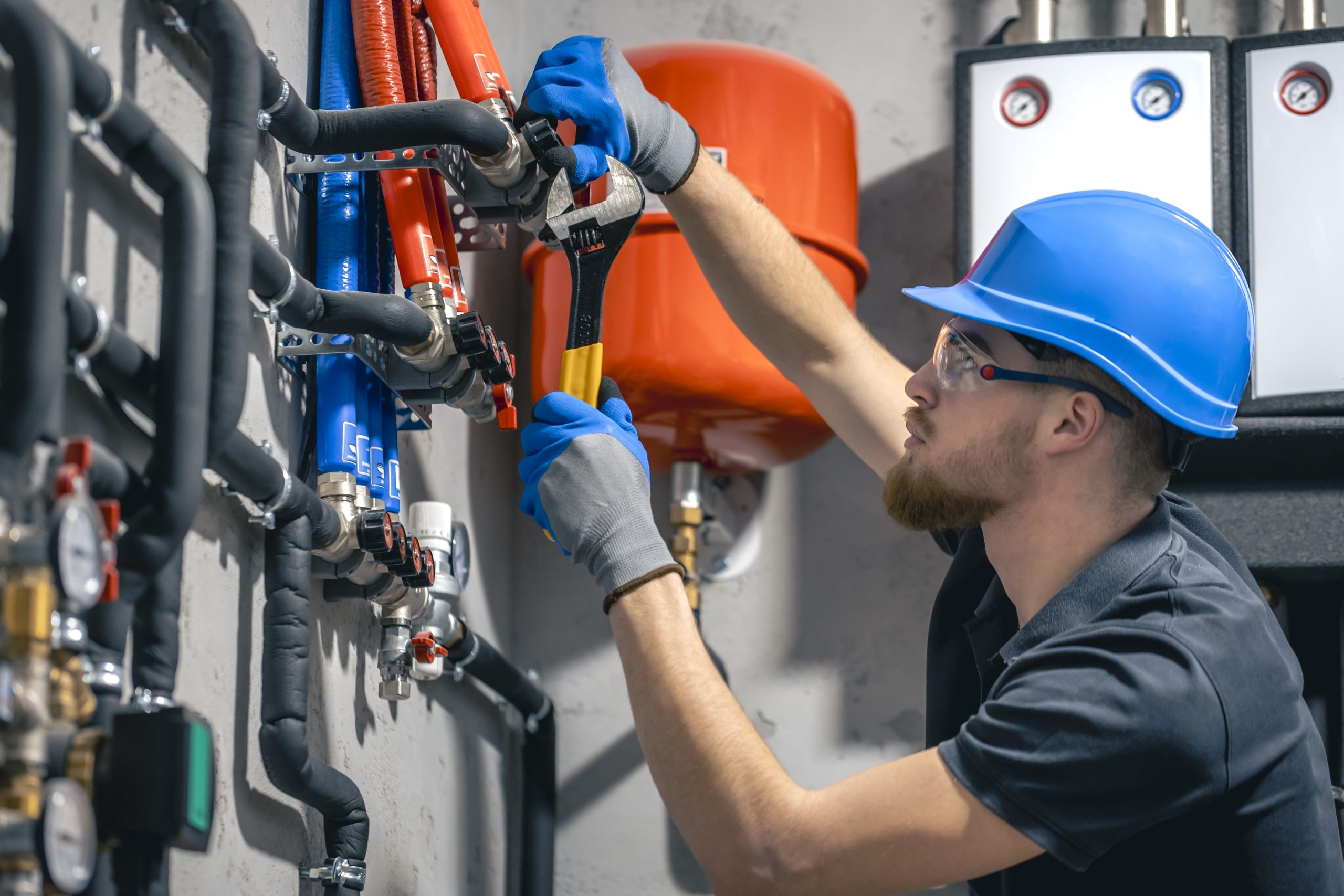 Sanitary & Plumbing man installs heating system house checks pipes with wrench